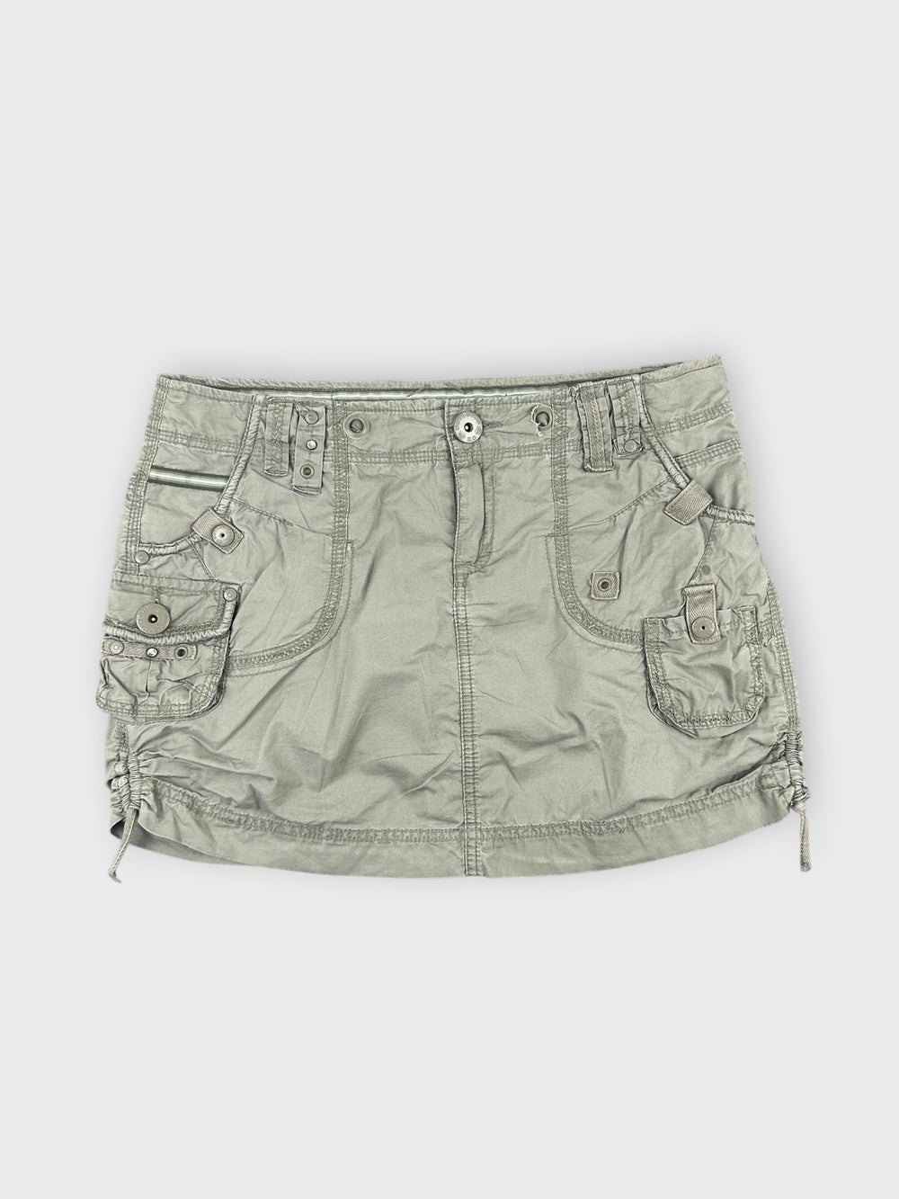 Faded green mini skirt with pocket details front view.