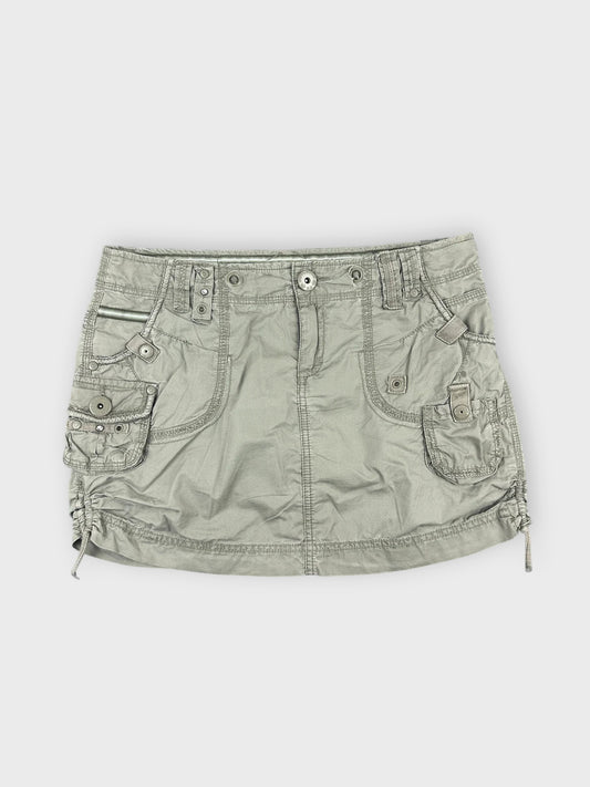 Faded green mini skirt with pocket details front view.