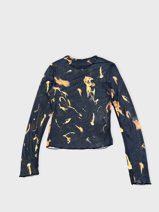Back view of a flame-print long sleeve top in black and orange.