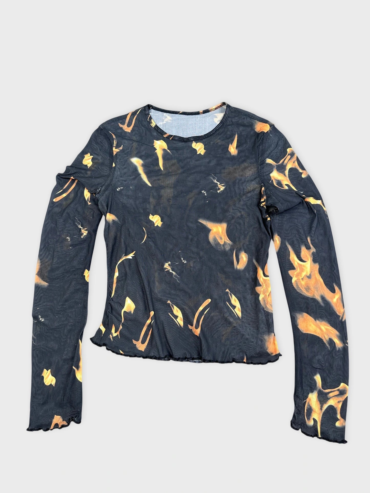 Detail view of a flame-print graphic top featuring black and orange colors.