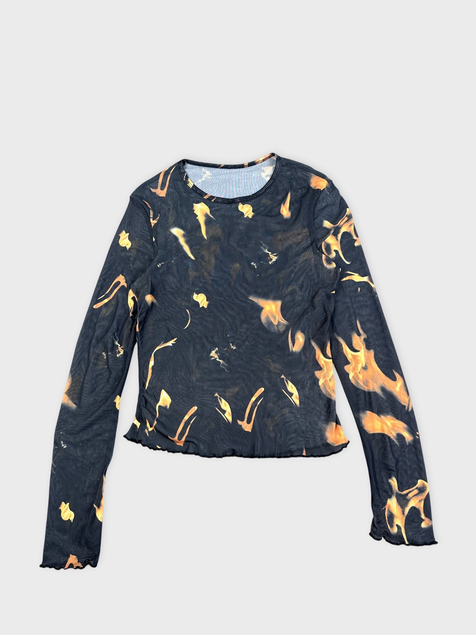 Front view of a black flame-print graphic top with long sleeves.