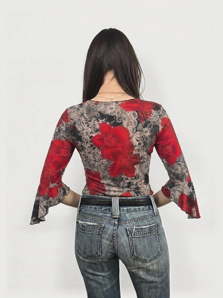 Back view of a floral bell sleeve top in red and black with lace pattern.