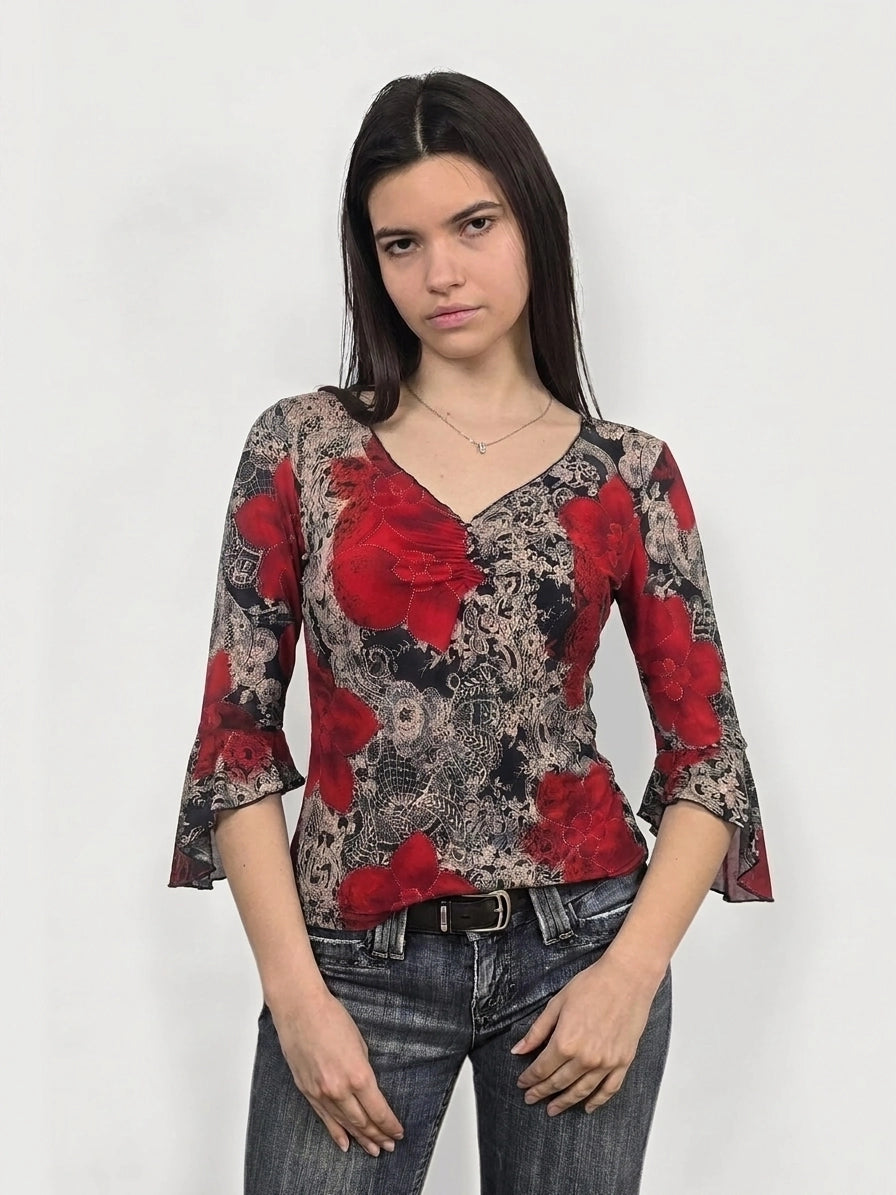 Front view of a floral bell sleeve top in red with lace pattern.