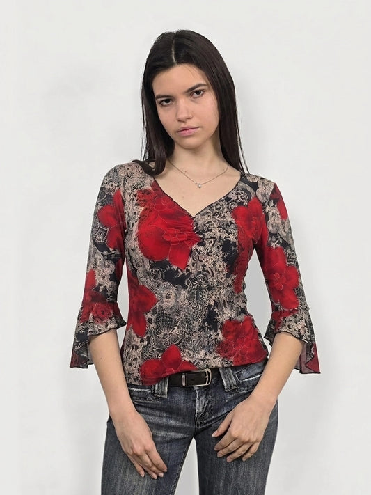 Front view of a floral bell sleeve top in red with lace pattern.