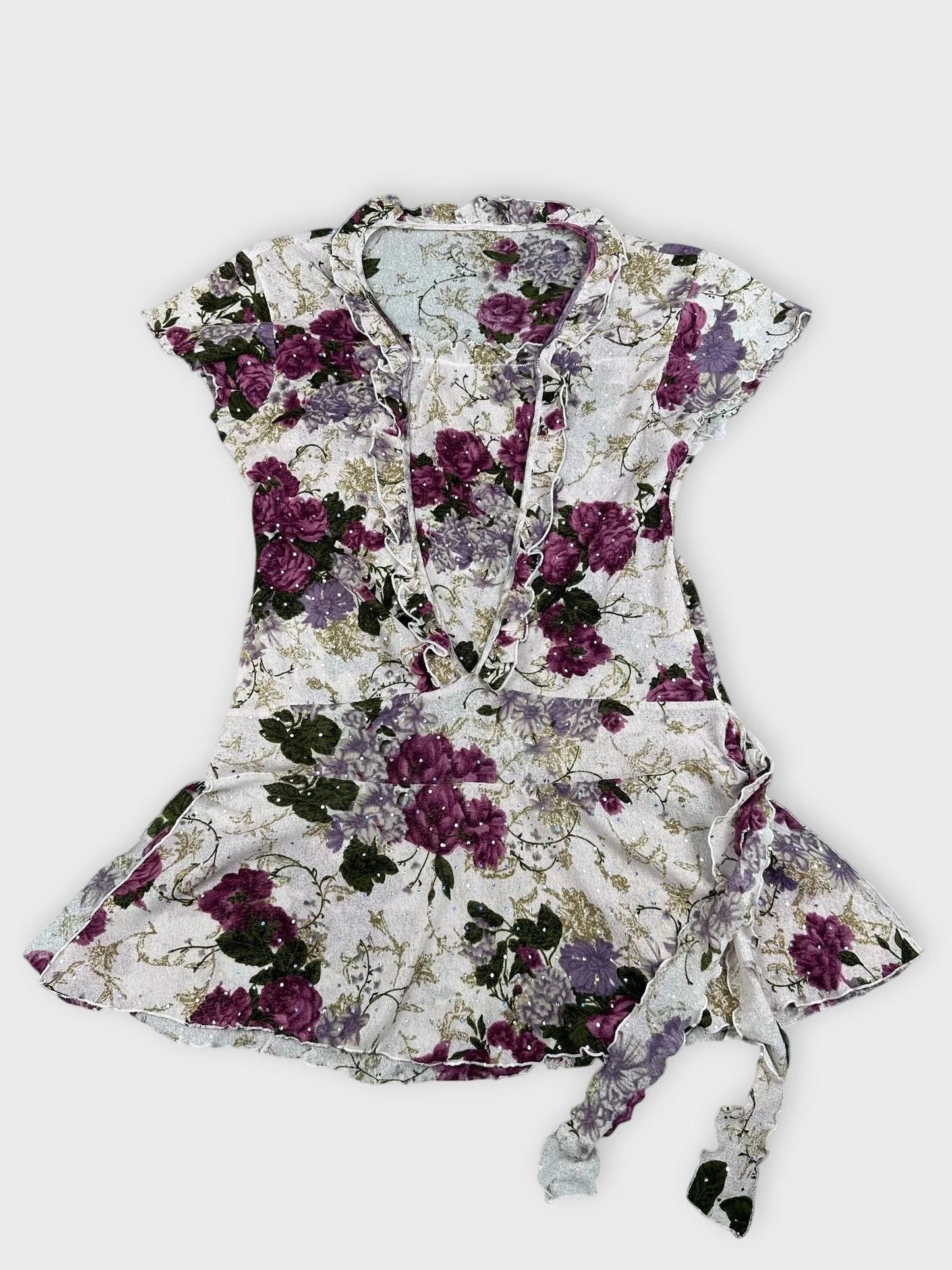 Detail view of floral frill mesh top in purple and pink with ruffled neckline.