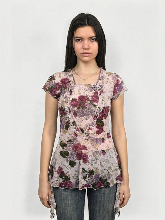 Front view of a floral mesh top in pink, featuring ruffled trim.