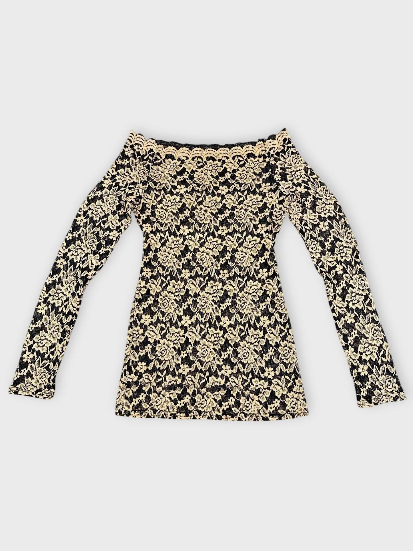 Detail view of black and beige floral lace Bardot top with off-shoulder design.