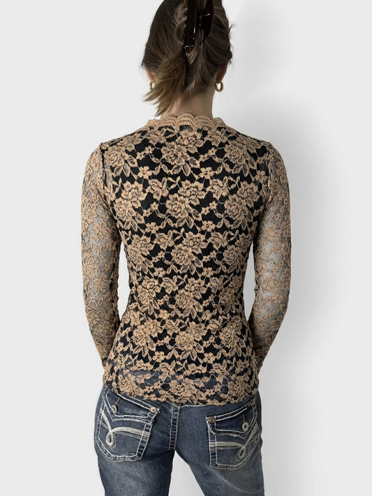 Back view of a black and beige floral lace bardot top featuring a scalloped neckline.