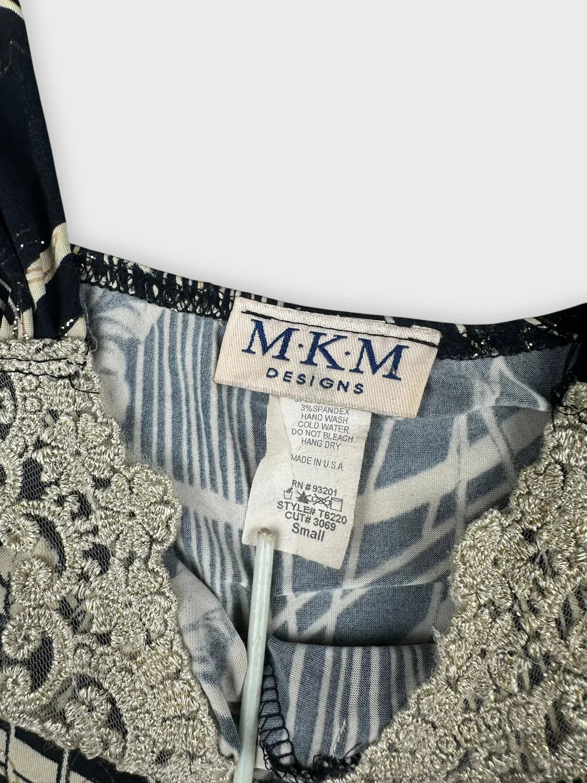 Detail view of a black floral lace trim tank top with a decorative neckline.