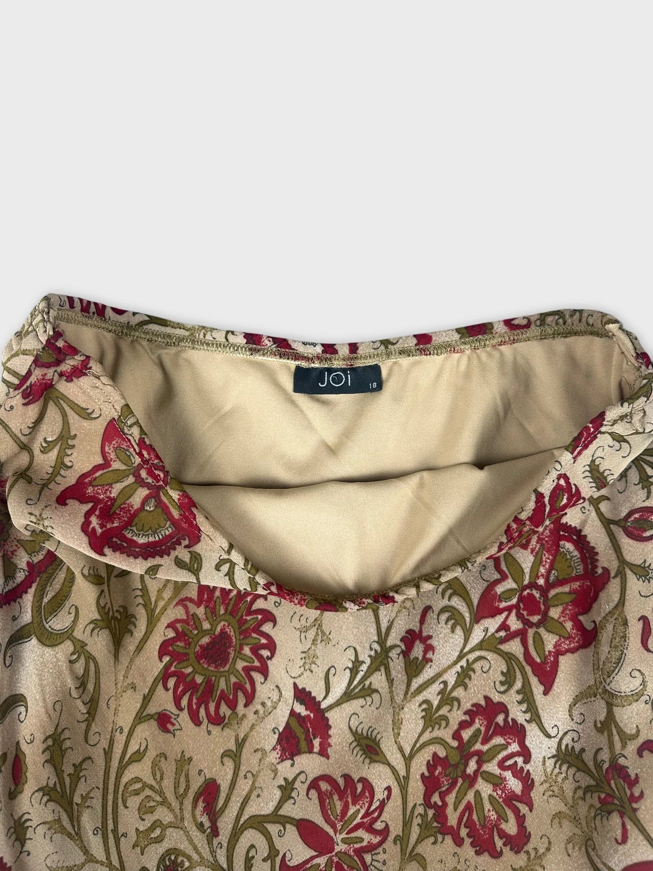 Detail view of floral maxi skirt featuring a beige background and red floral print.