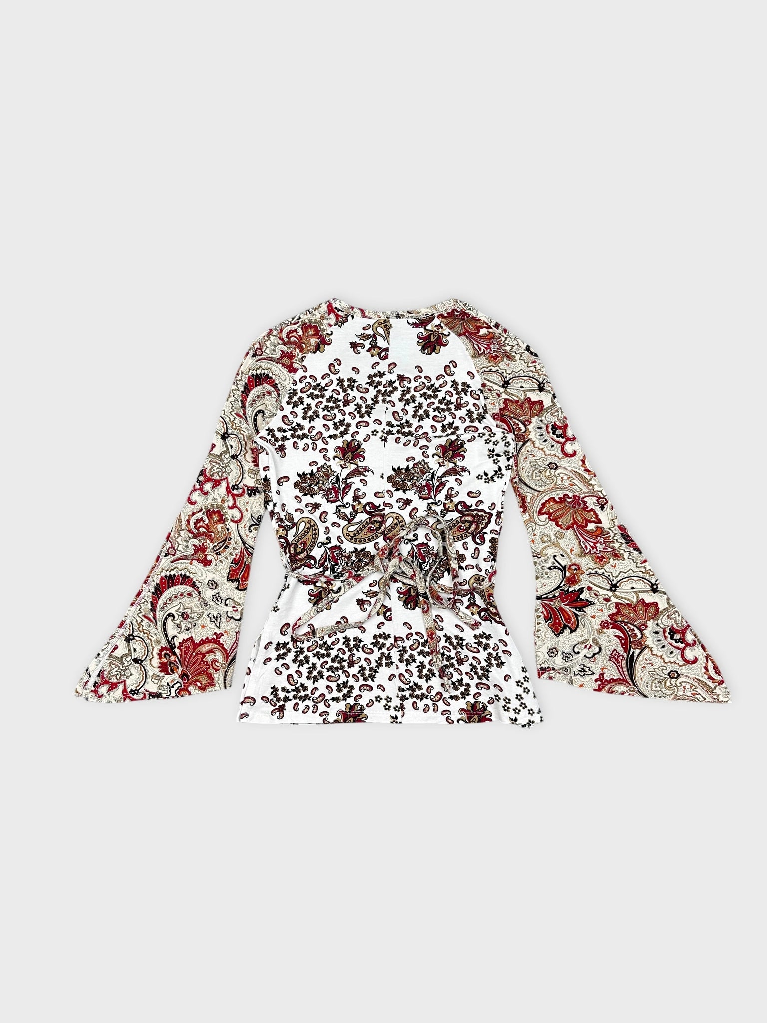 Back view of a long-sleeve white top with floral paisley print.