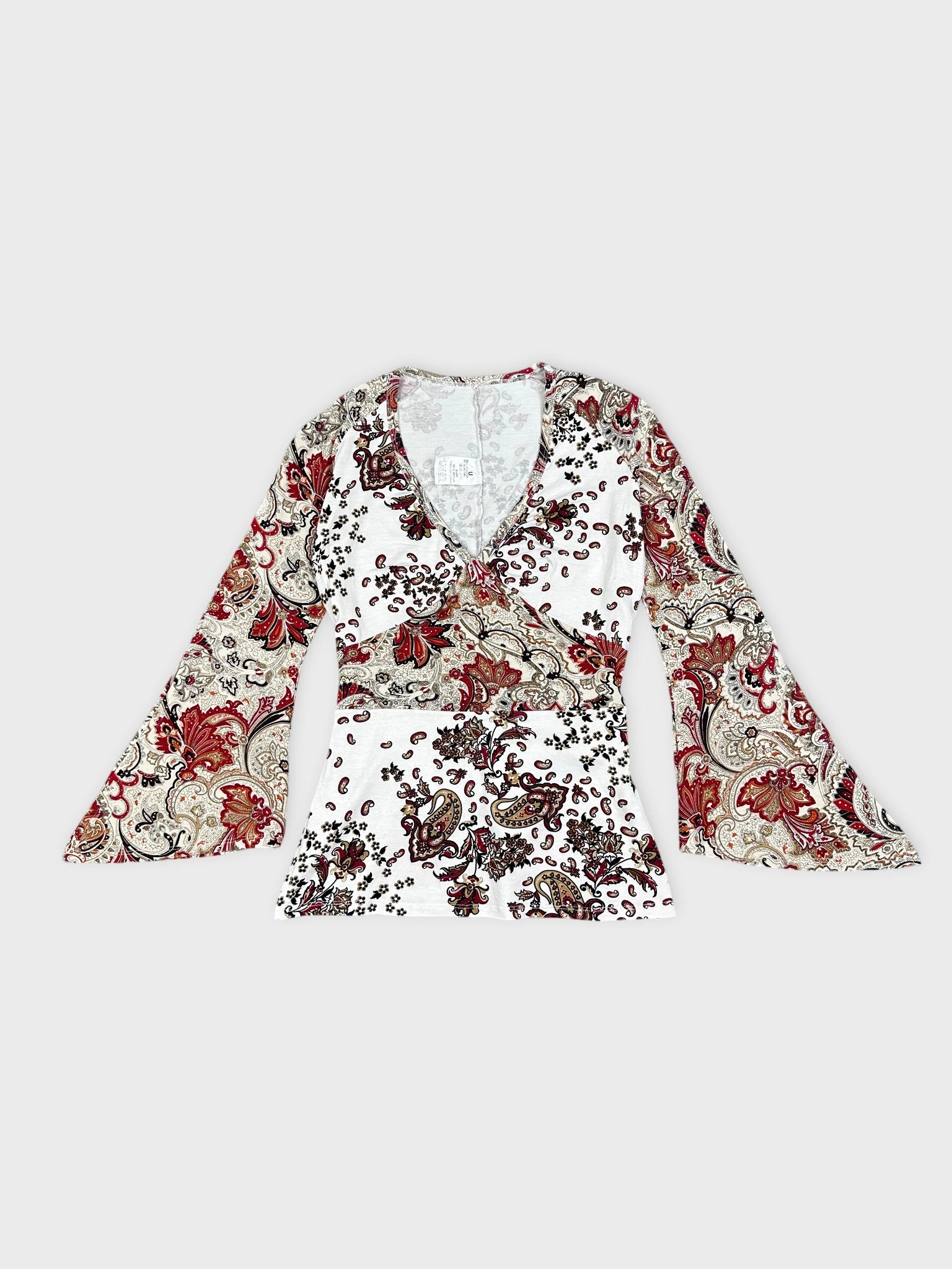 Front view of white long-sleeve top with floral paisley print and V-neck.