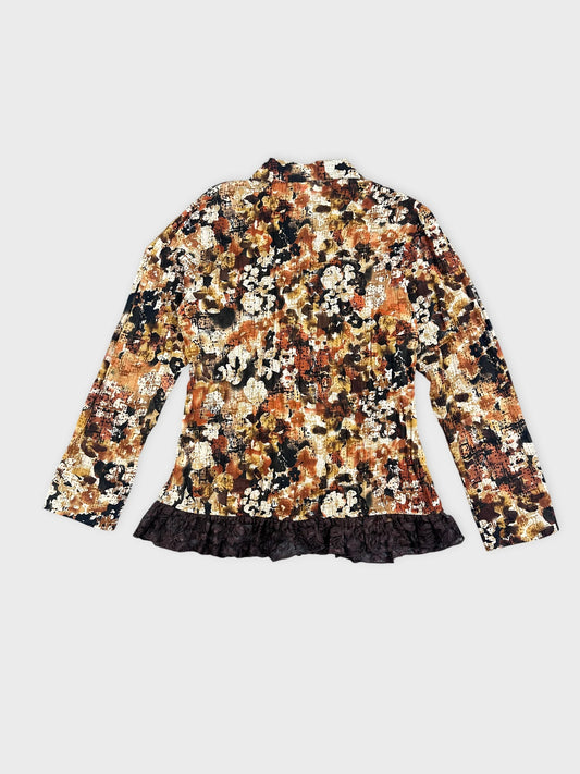 Back view of a floral-patterned blazer in brown with a ruffled hem.