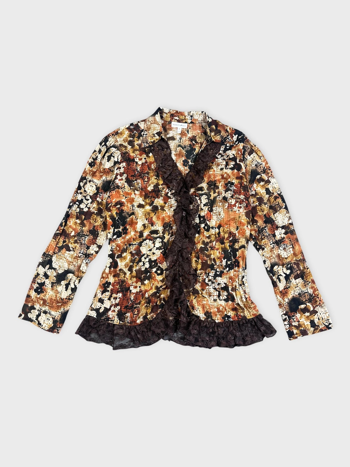 Detail view of a floral-patterned blazer in black and orange with lace trim.