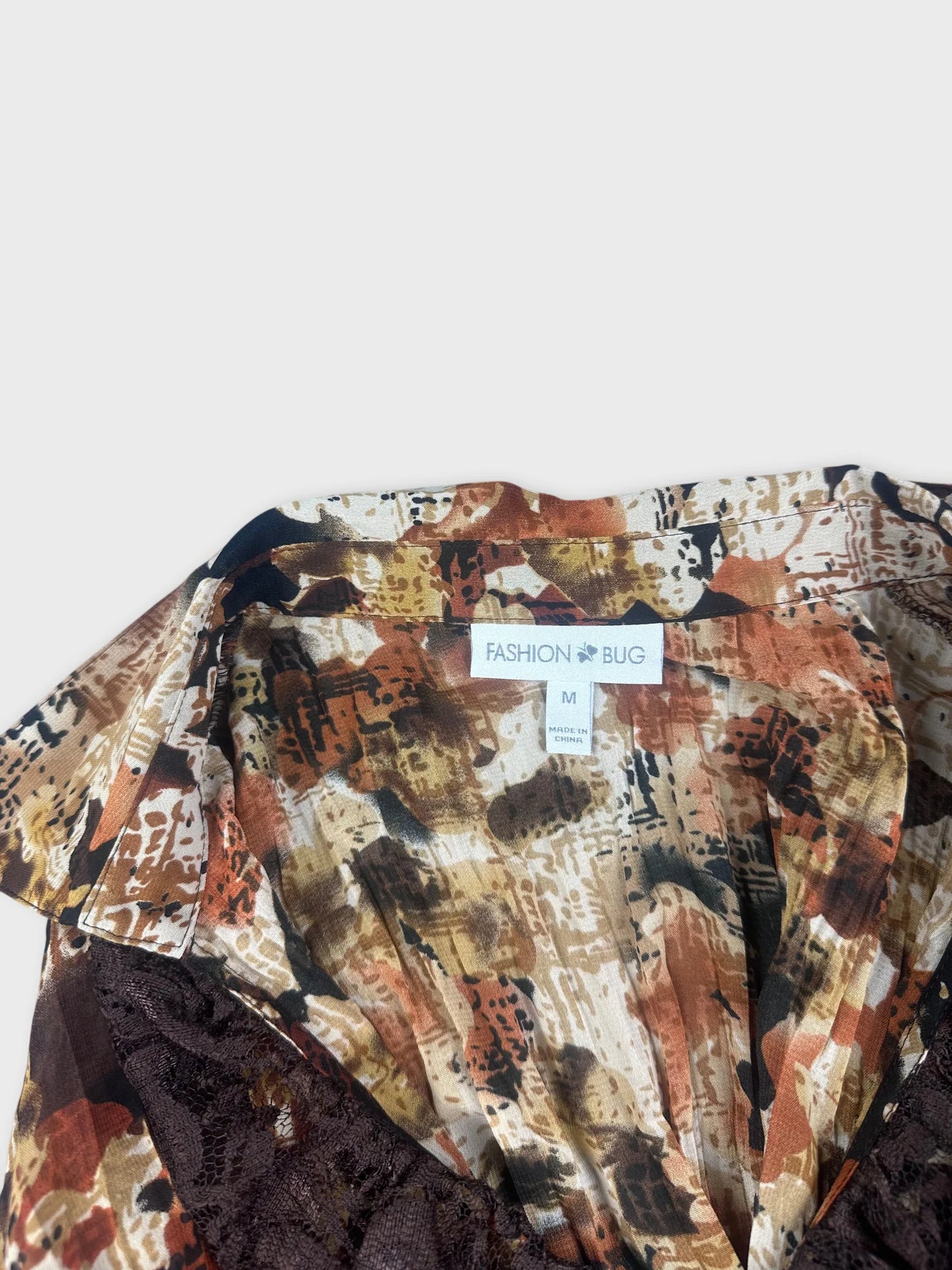 Detail view of a floral-patterned blazer primarily in warm earth tones.
