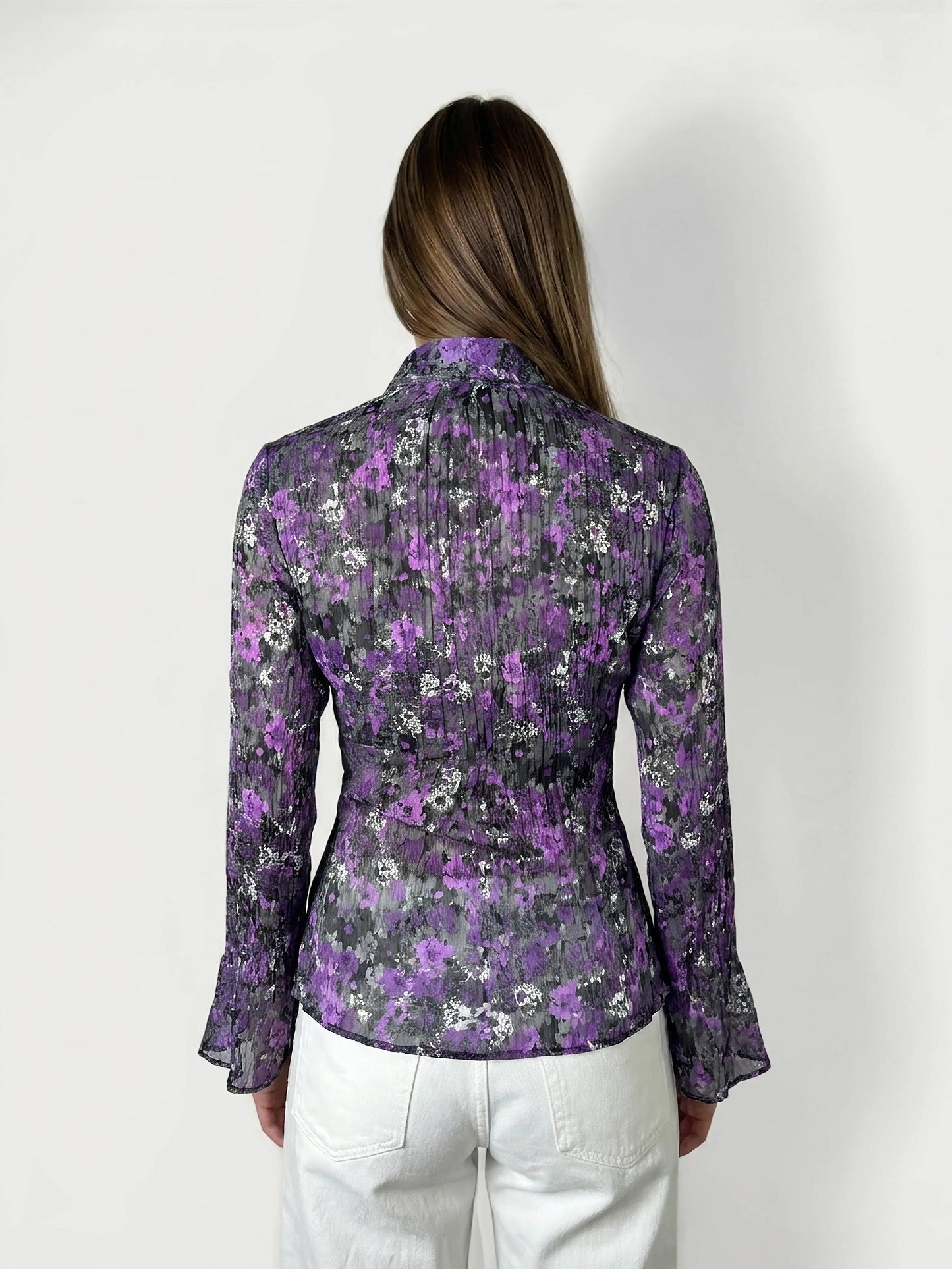 Back view of a floral ruffle blouse in purple with bell sleeves.