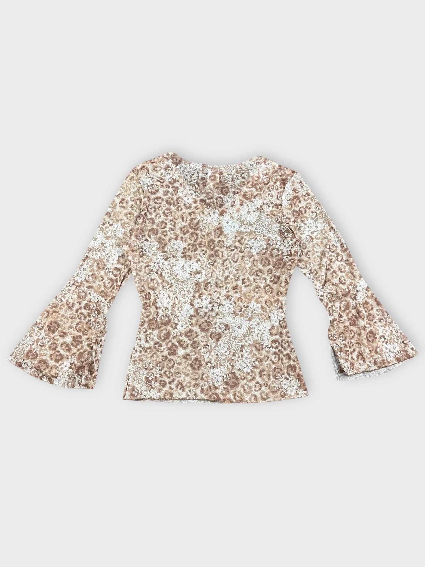 Back view of floral V-neck top with bell sleeves in earthy tones