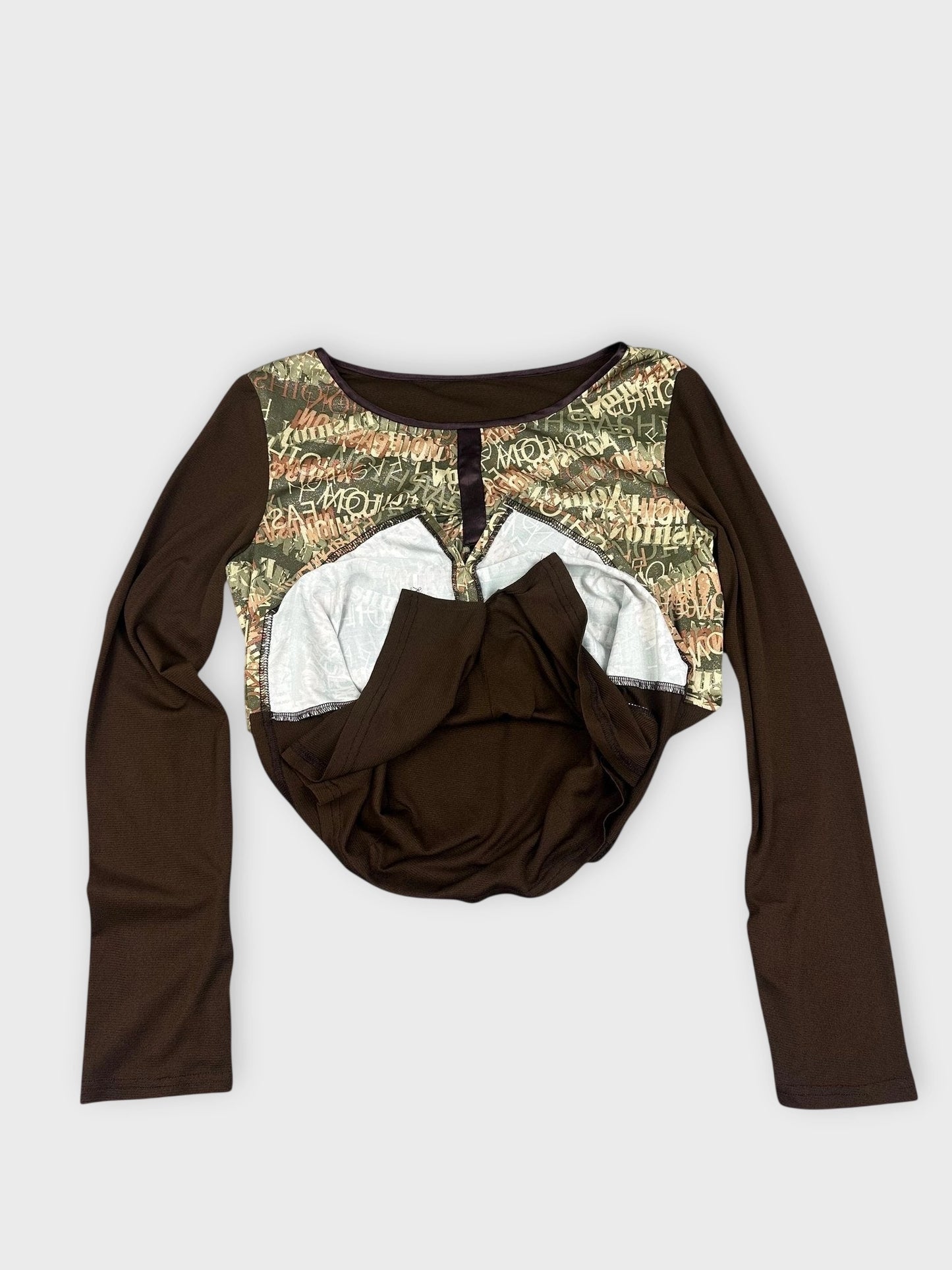 Detail view of a grunge longsleeve top in khaki green with text print.