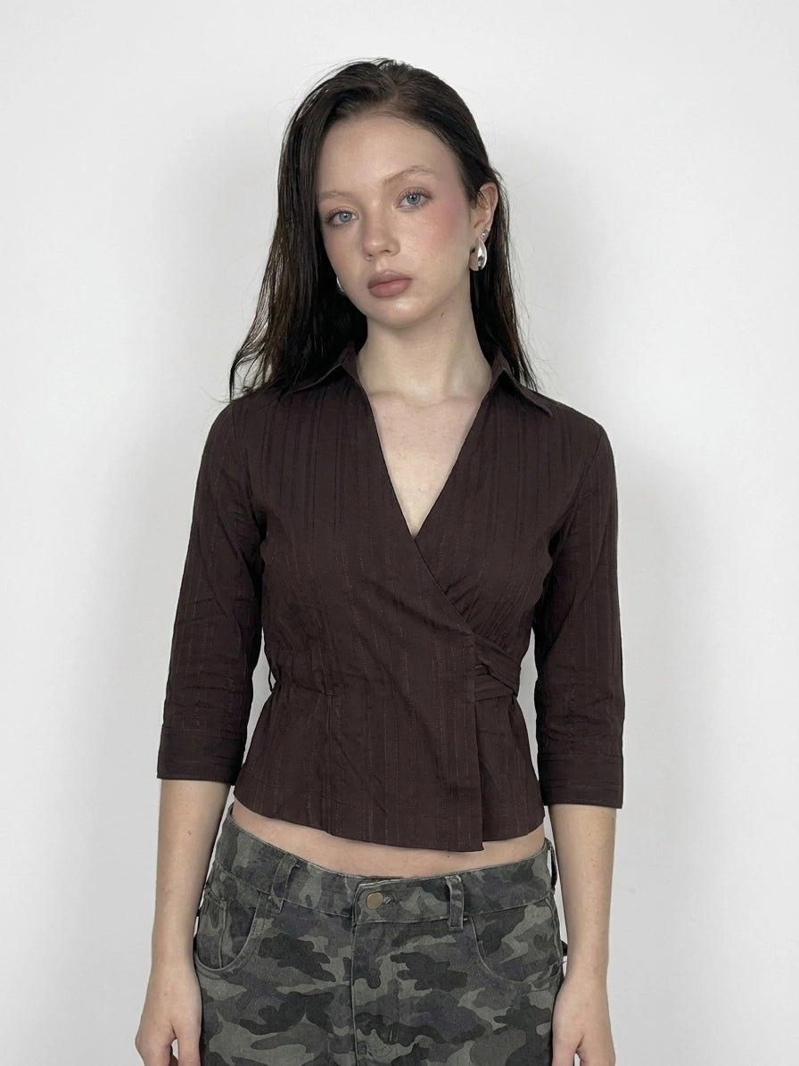 Front view of a brown grunge wrap blouse with a self-tie detail.