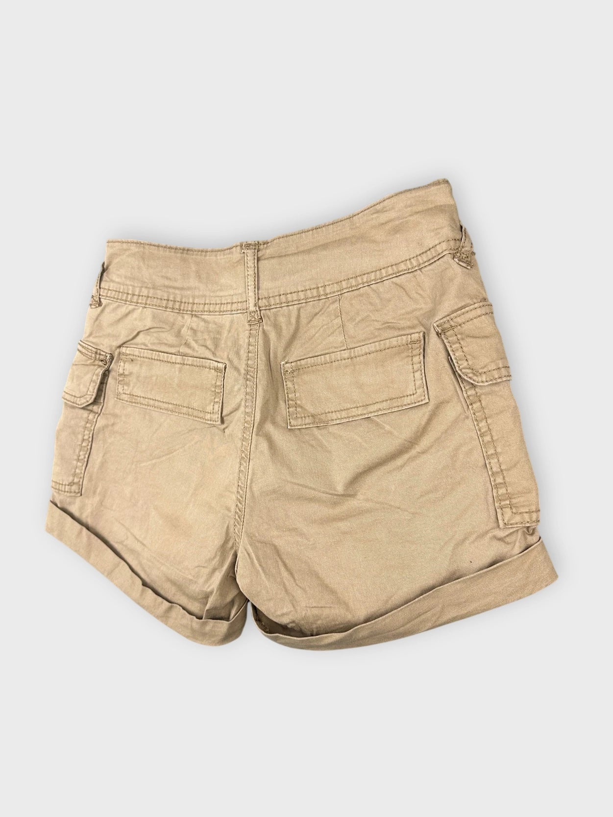Detail view of khaki mini cargo shorts with side pockets and straps.