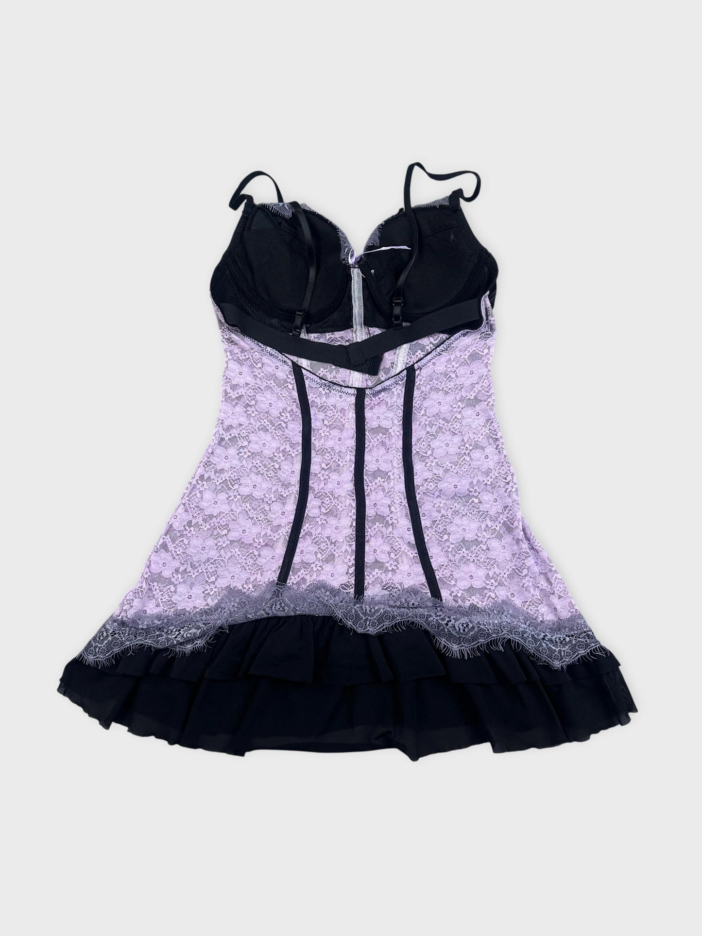 Lace corset in black and lavender with ruffled hem detail view.