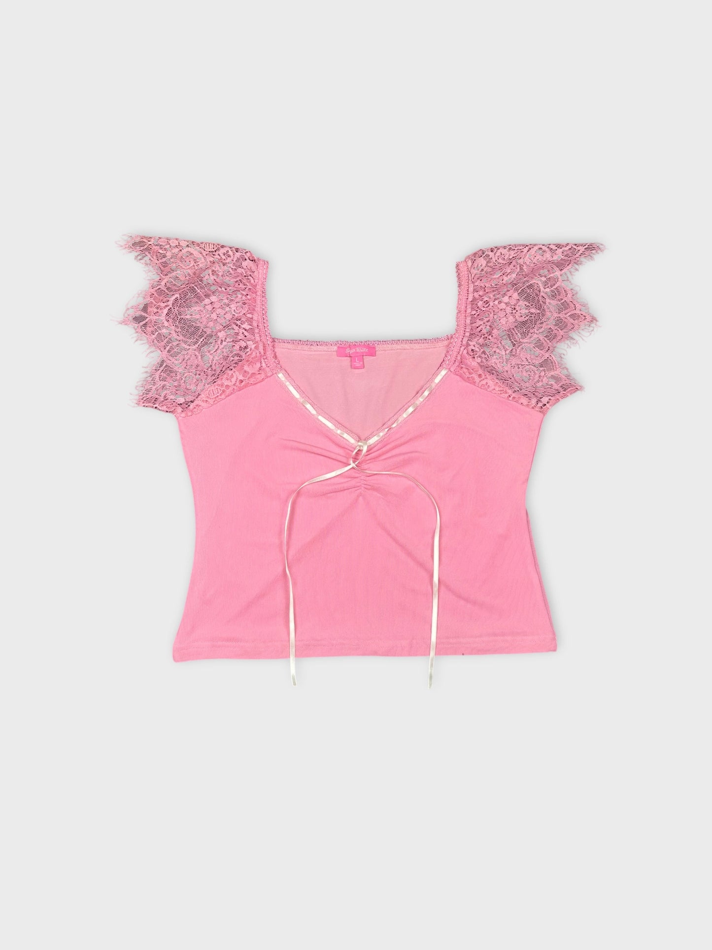 Front view of pink crop top featuring lace trim and tie detail.