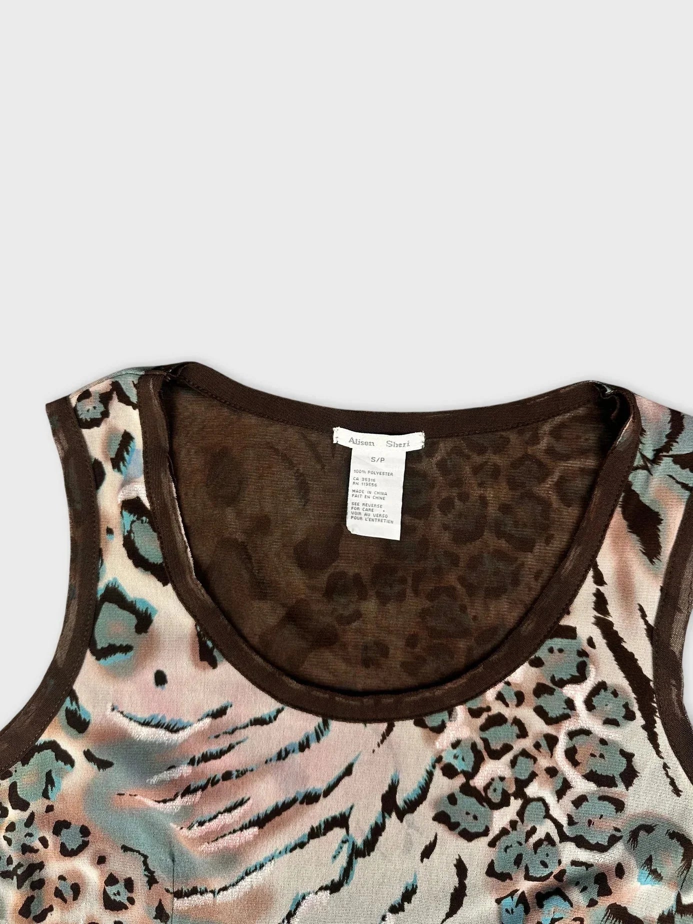 Leopard print flare top in beige and blue detail view with sheer neckline.
