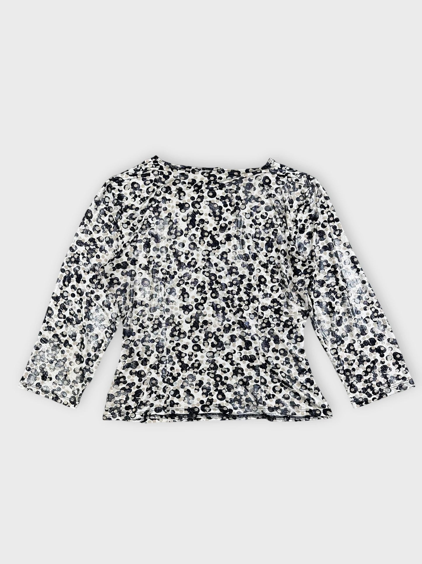Back view of a leopard print long sleeve top with a shimmering pattern.