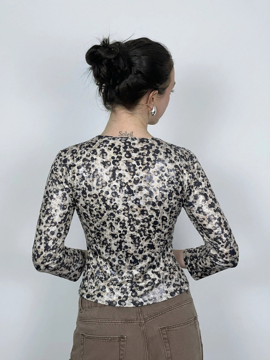 Back view of a leopard print long sleeve top with shiny texture.