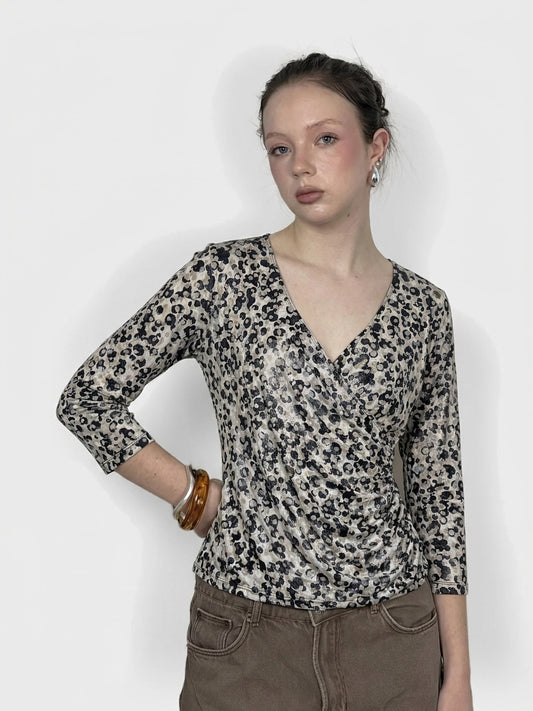 Leopard print long sleeve top in beige with a draped neckline, front view.