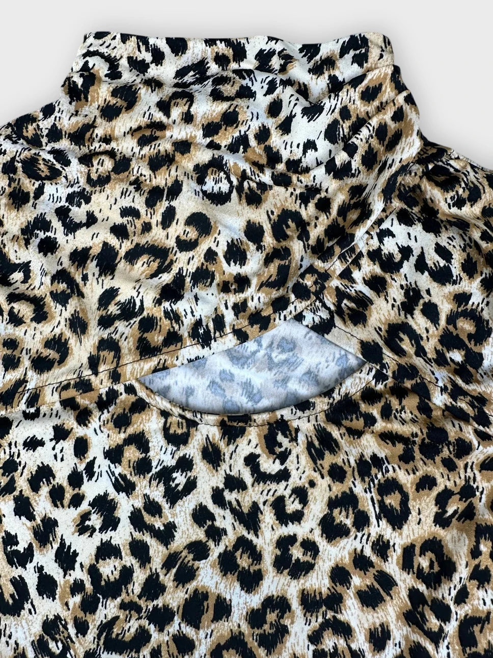Detail view of a leopard print long sleeve top with a cutout