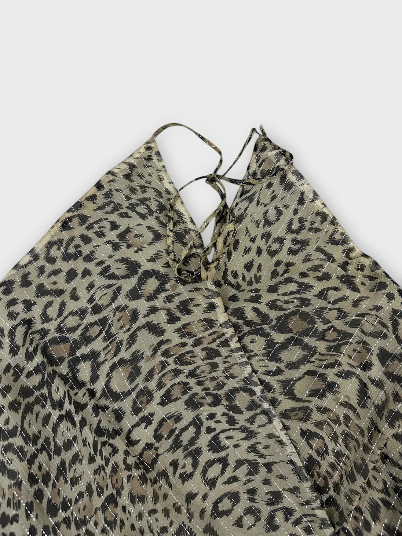 Detail view of leopard print silk halter top in olive green with tie straps.