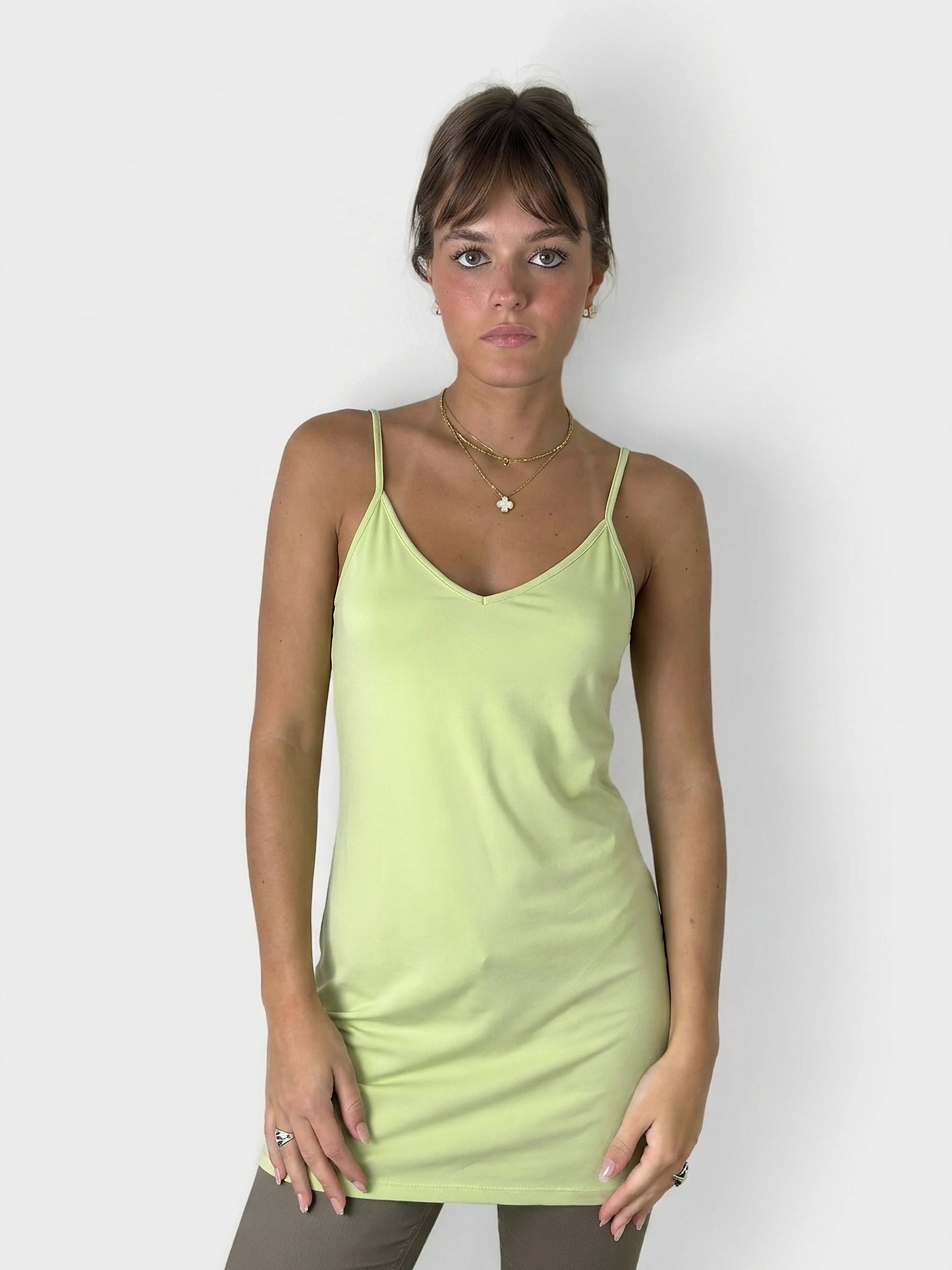 Front view of a lime green slip dress featuring adjustable straps.