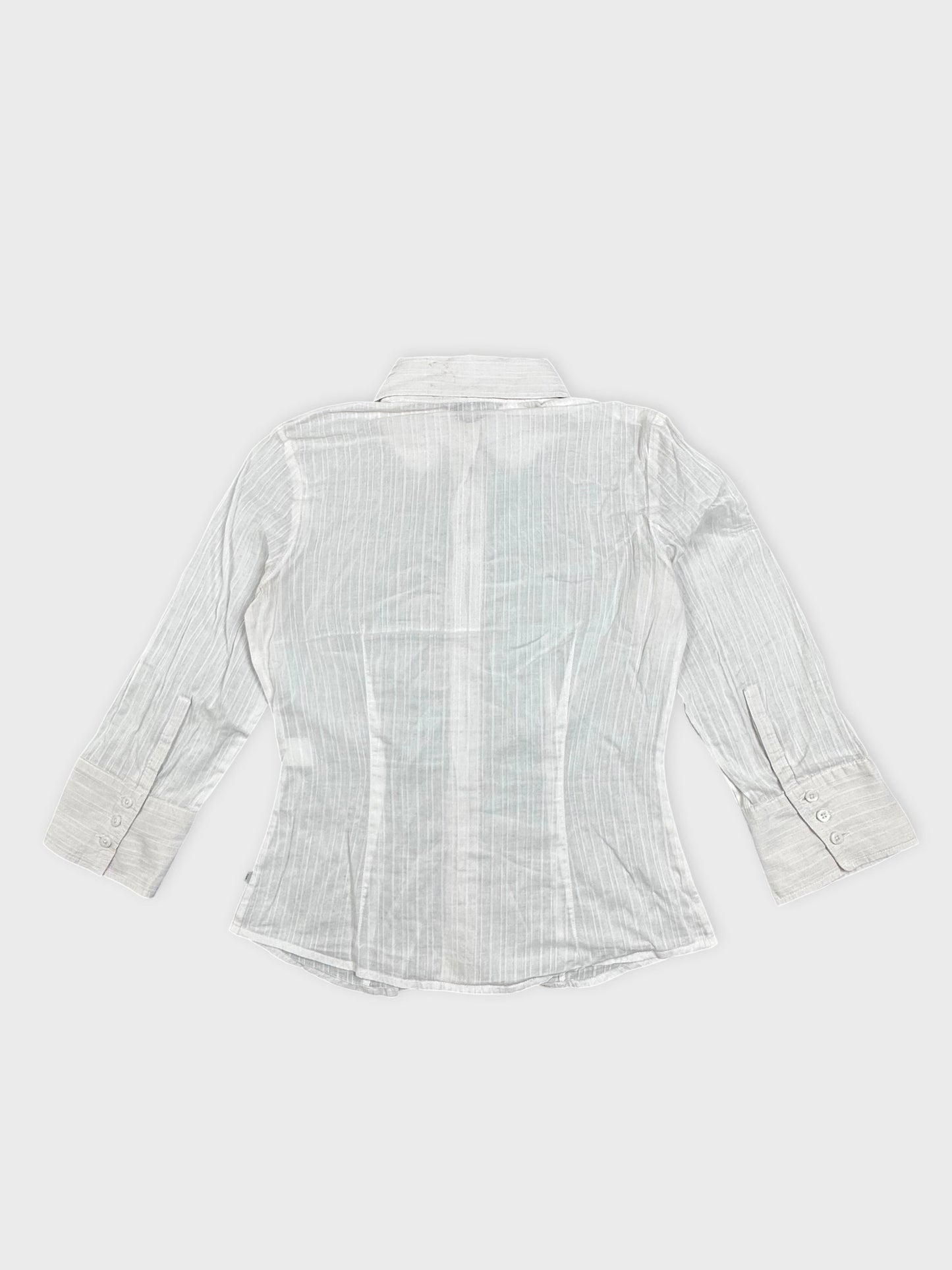 Back view of a white shirt featuring vertical stripes and buttoned cuffs.