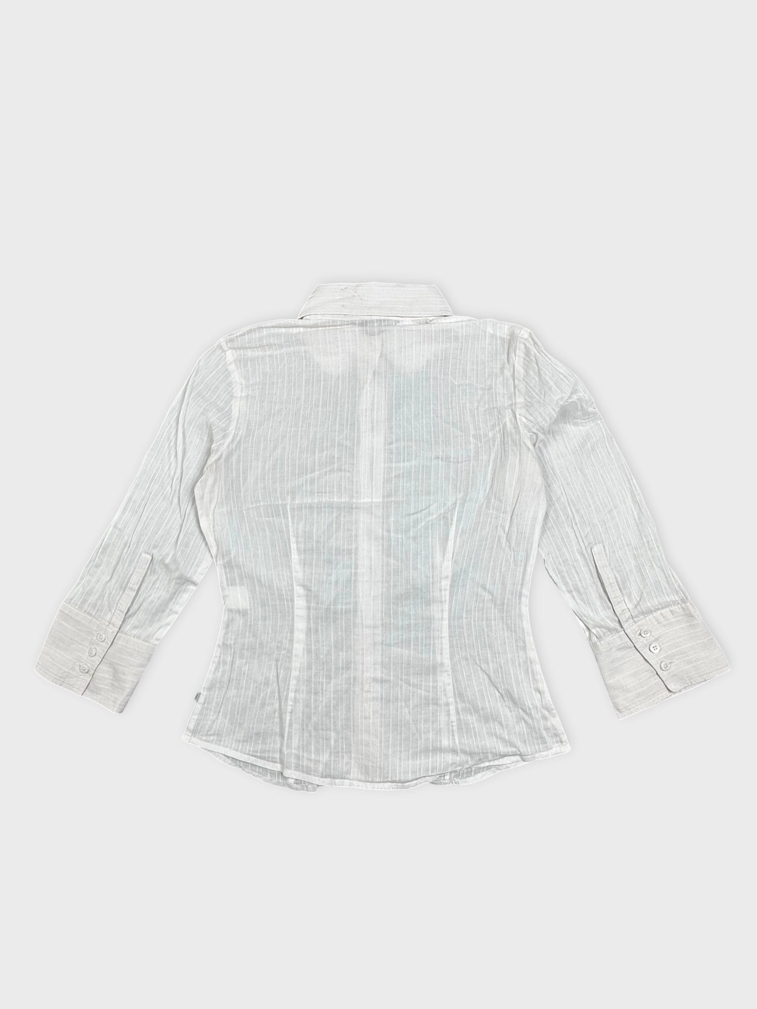 Back view of a white shirt featuring vertical stripes and buttoned cuffs.