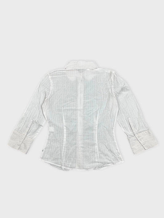 Back view of a white shirt featuring vertical stripes and buttoned cuffs.