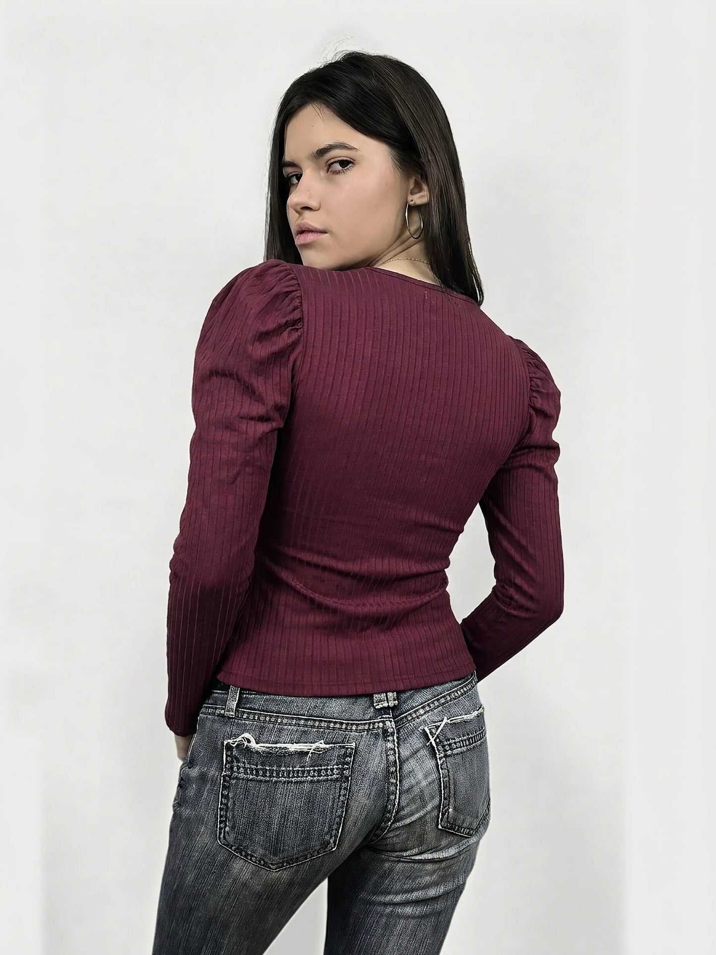 Back view of a maroon ribbed long sleeve top with puffed shoulders.
