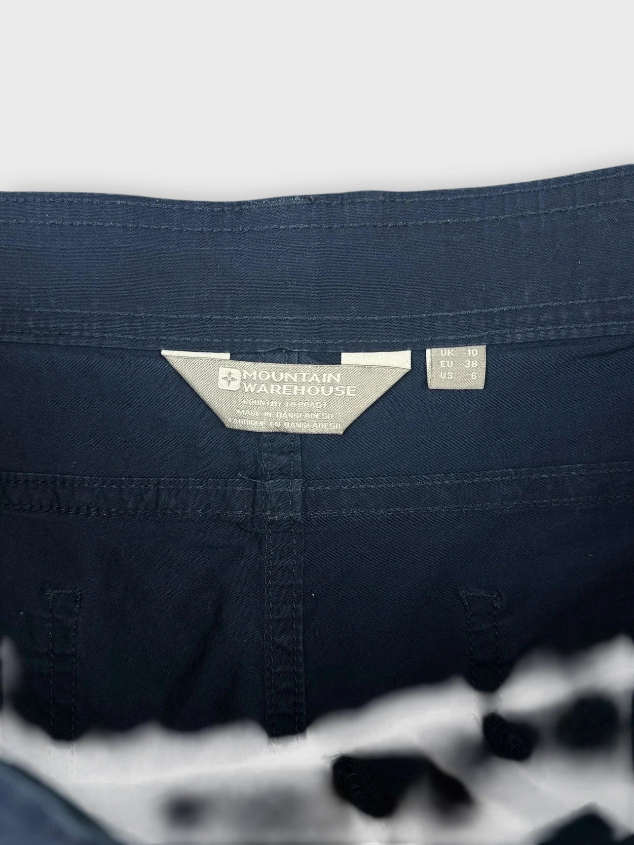 Navy cotton mini shorts detail view showing sleek pockets and stitching.