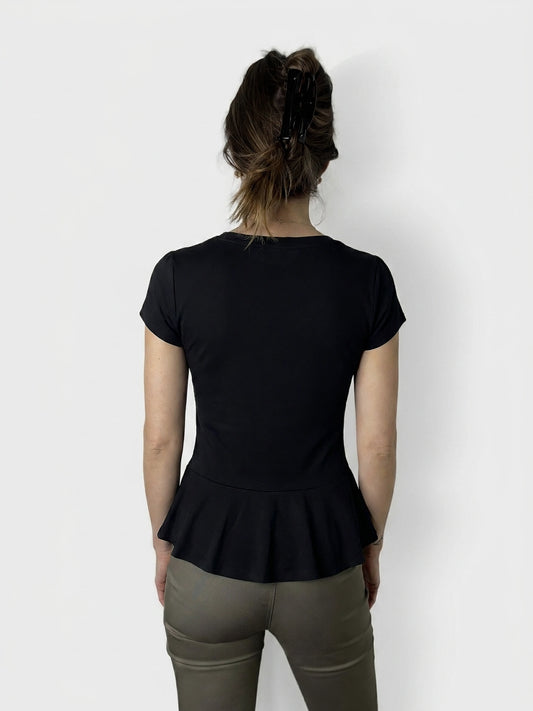 Back view of a navy peplum body shirt with button detail.