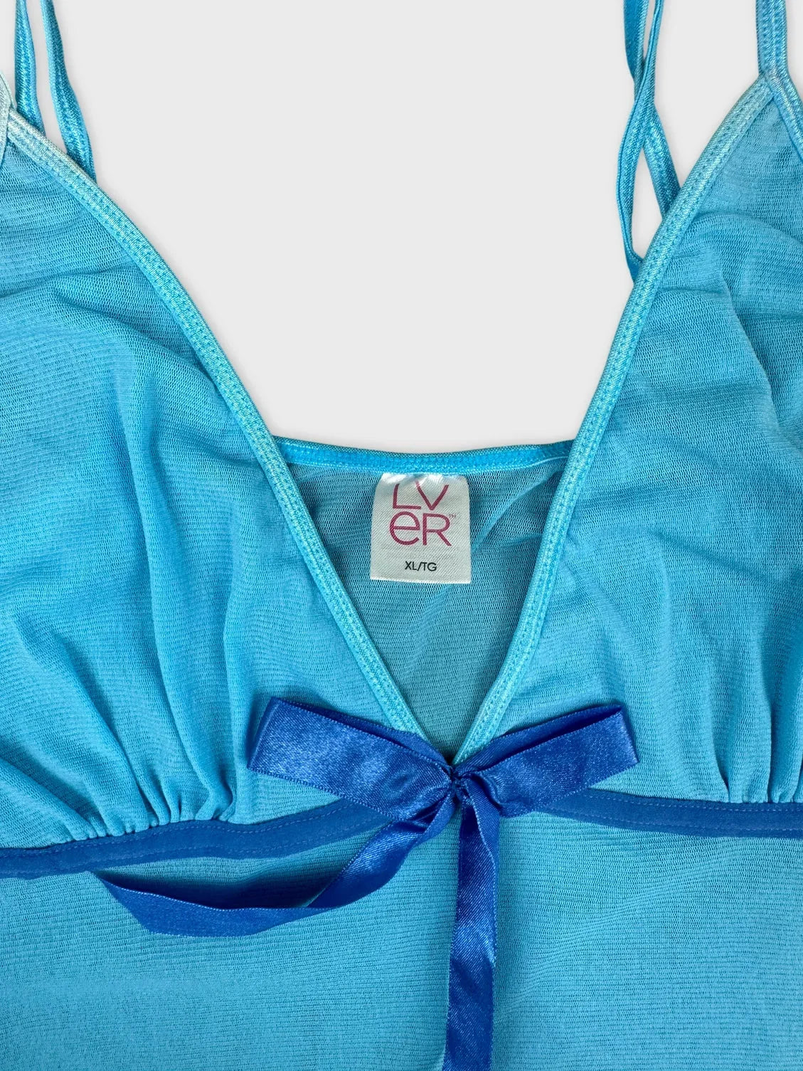 Ocean blue sheer camisole with bow detail in detail view.