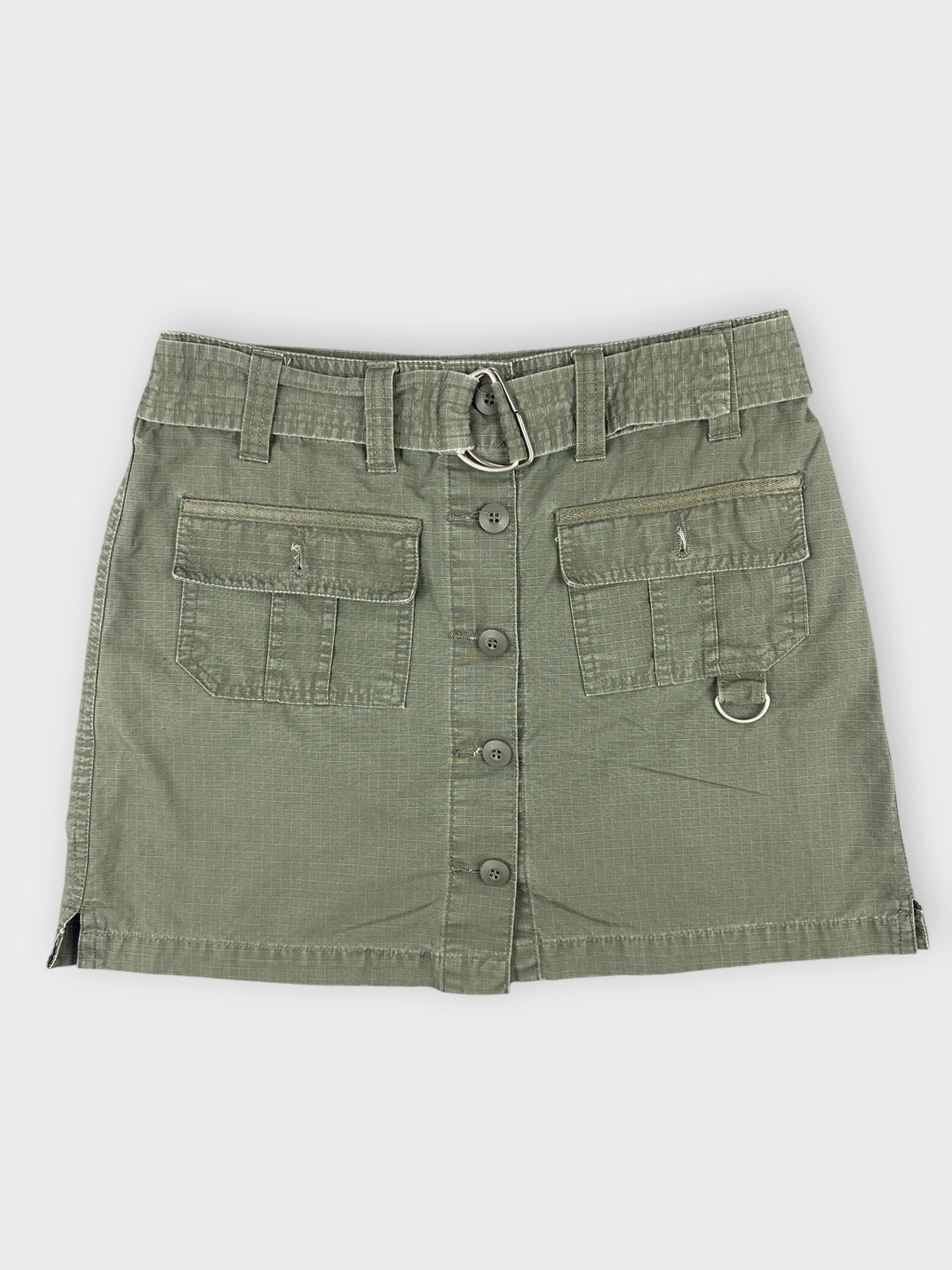 Front view of an olive mini skirt with pockets and button detail.