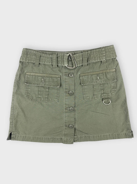 Front view of an olive mini skirt with pockets and button detail.