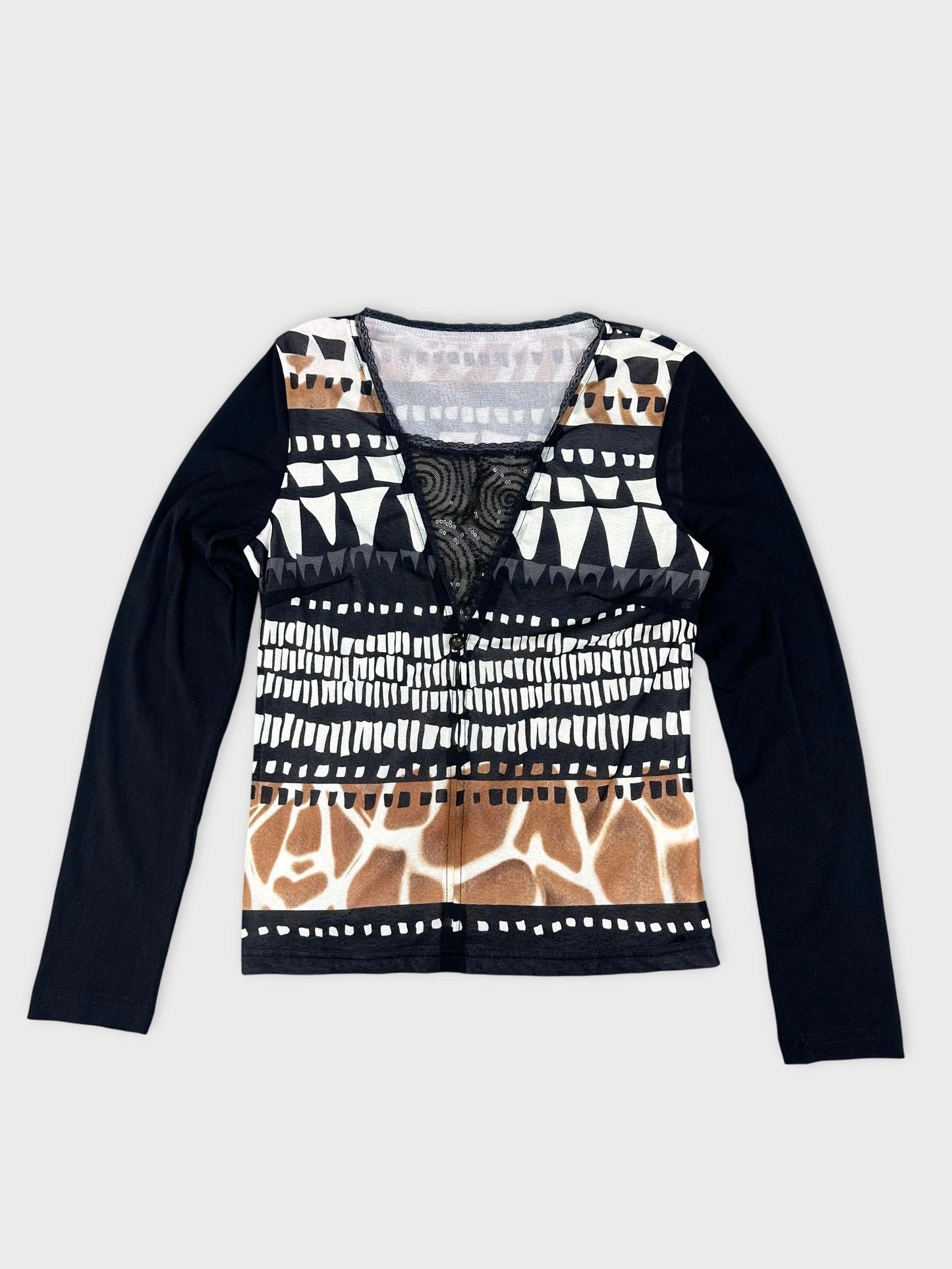 Detail view of a patterned long sleeve top in black with sheer detail.