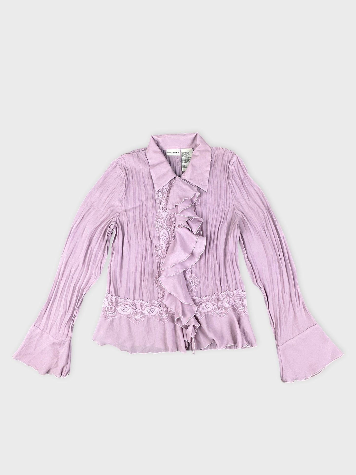 Detail view of a pink button-up shirt with ruffle and lace trim.