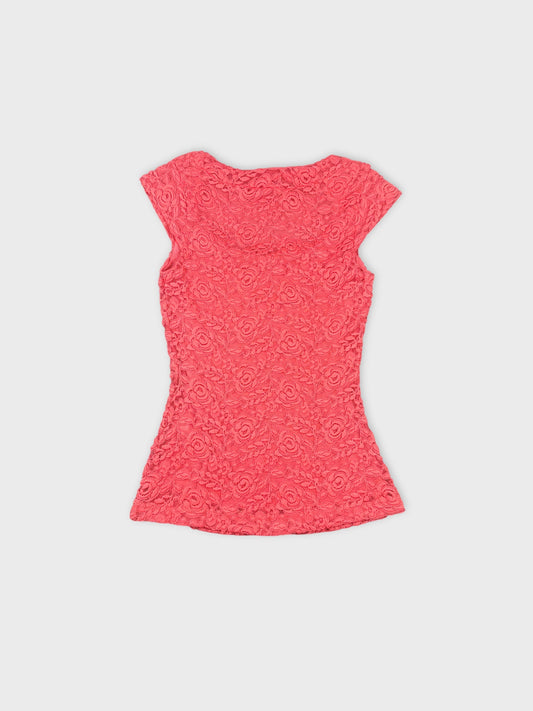 Back view of a pink floral lace crop top with short sleeves.