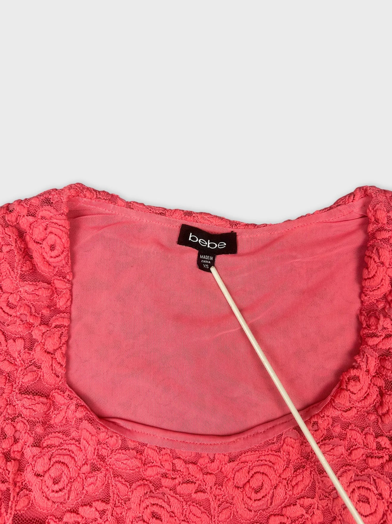 Detail view of a pink floral lace crop top with a round neckline.