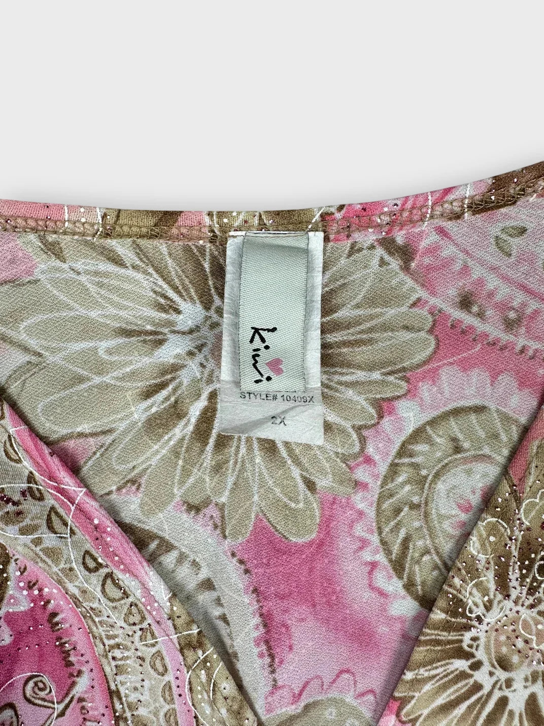 Detail view of pink floral wrap top showing neckline and print design.