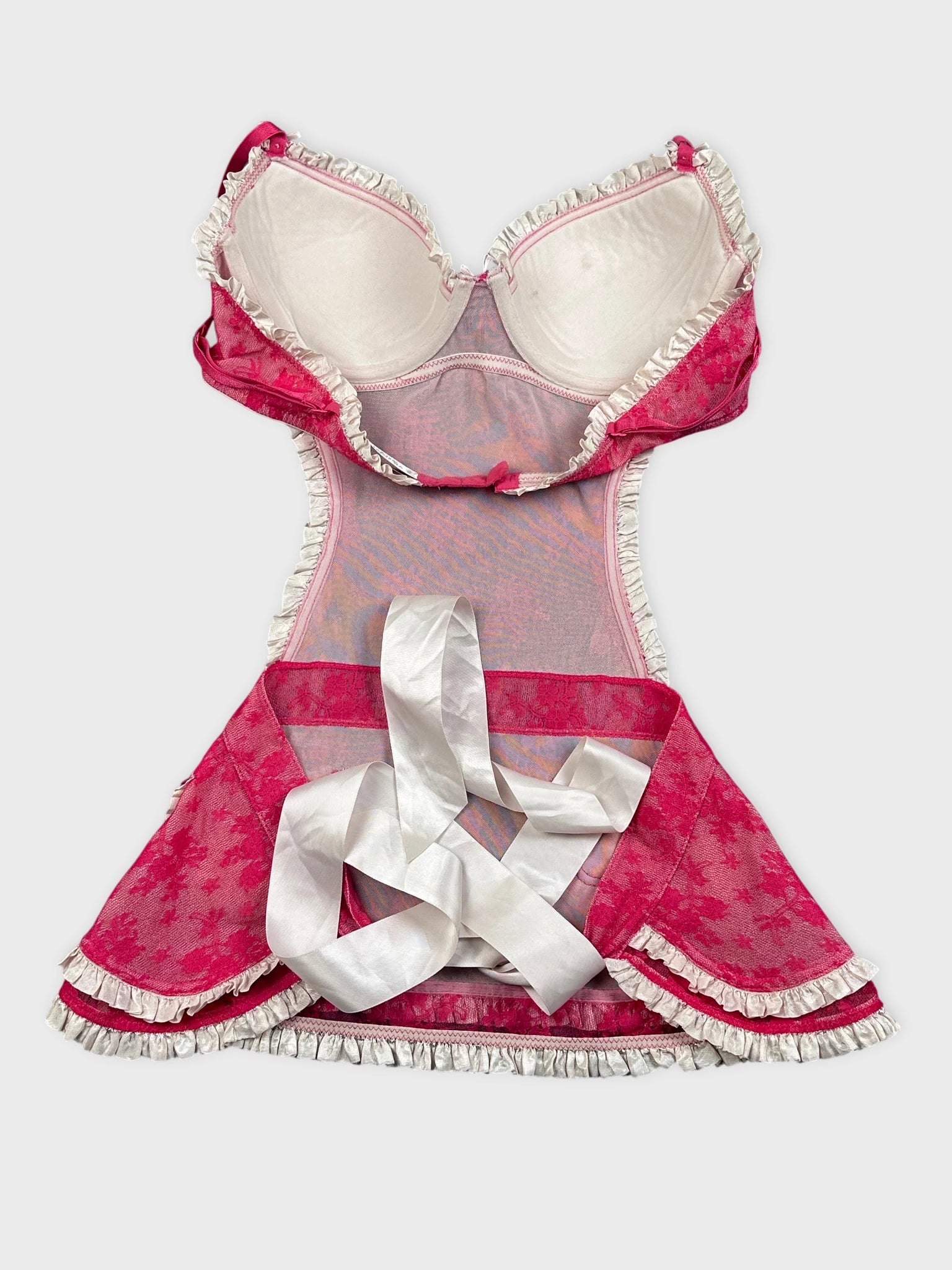Back view of a pink vintage dress with lace trim and ribbon detail.