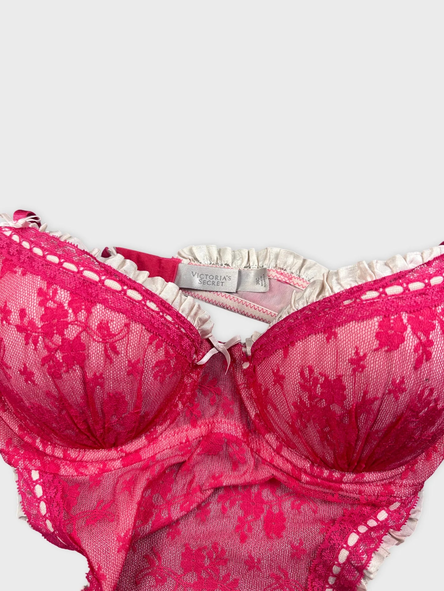 Detail view of pink lace lingerie featuring floral patterns and ruffled trim.