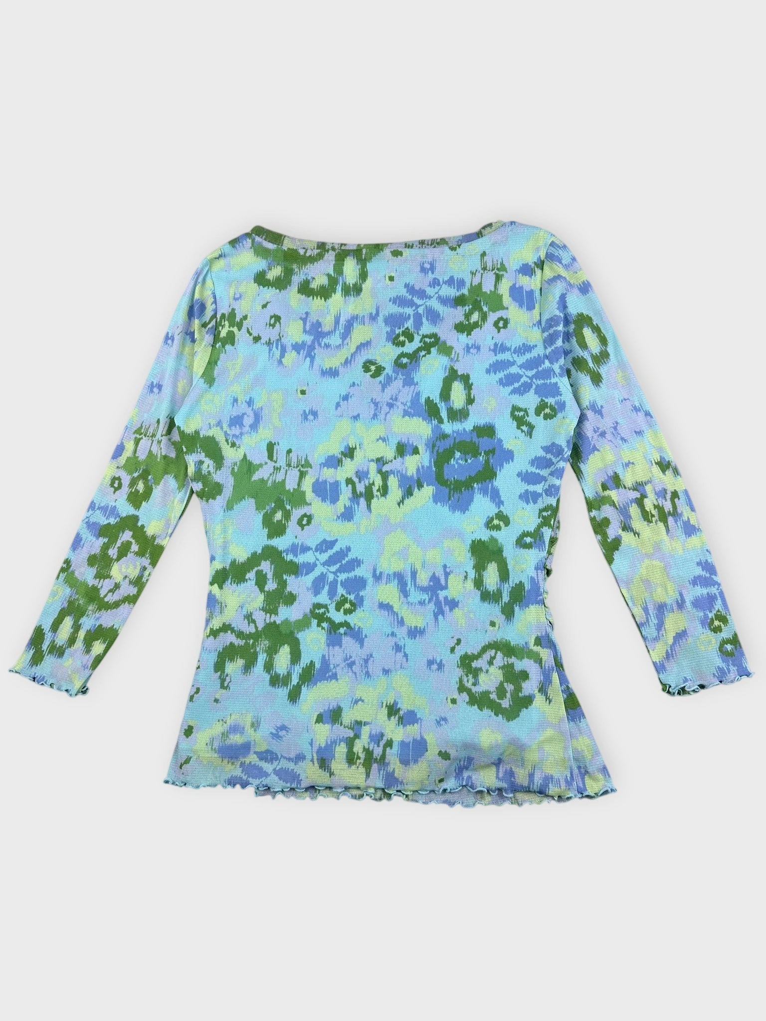 Back view of a printed v-neck top in blue and green with a flare hem.